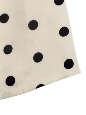Chic polka dot halter mini dress in apricot fabric with black dots.
