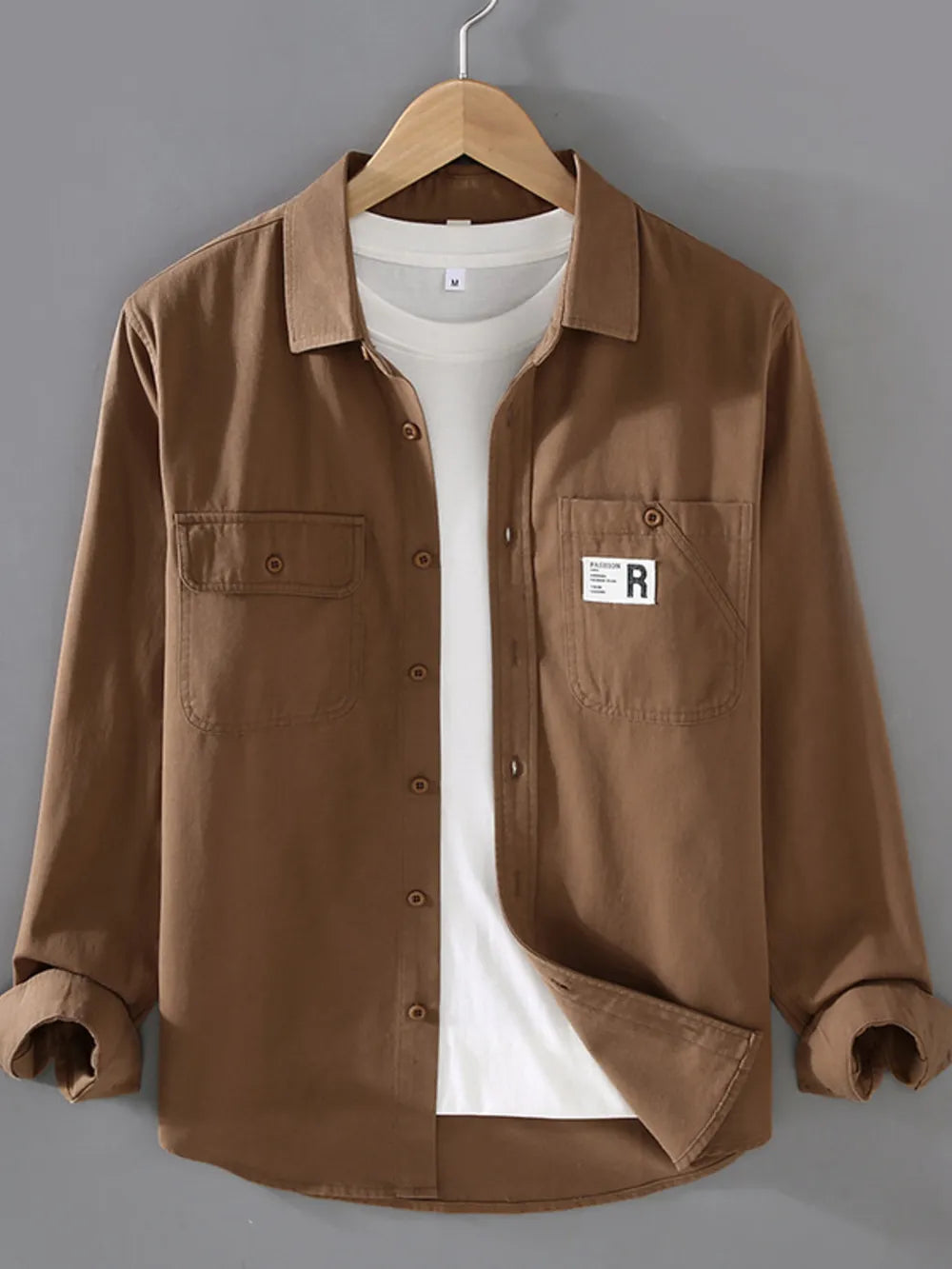 Brown cotton long-sleeve overshirt with two chest pockets and buttoned front.