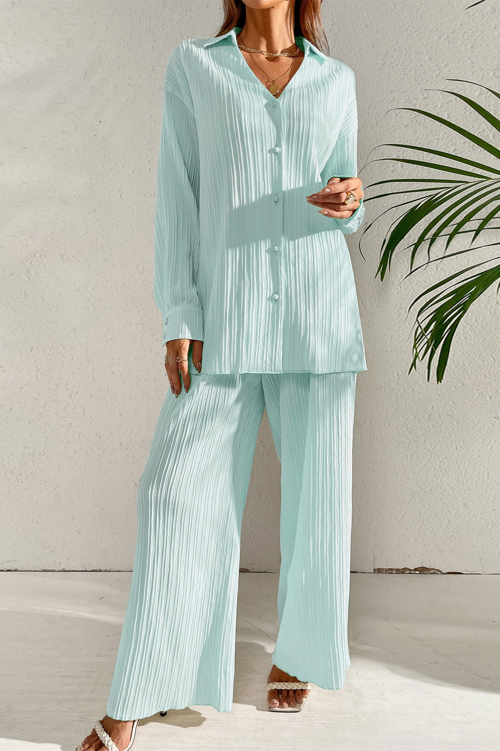 Pleated co-ord set in pastel blue featuring a button-down shirt and wide-leg trousers.
