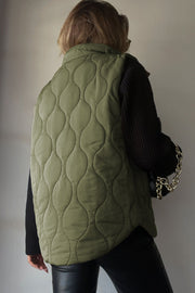 Quilted stand-collar gilet in Matcha Green with a wave pattern.