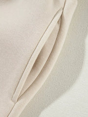 Beige cotton joggers with a side pocket detail.