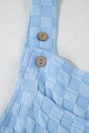 Light blue textured checkered jumpsuit with button straps and wooden buttons.