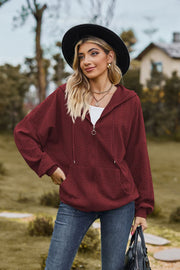 Burgundy textured cable knit zip-up hoodie with pockets and drawstring hood.