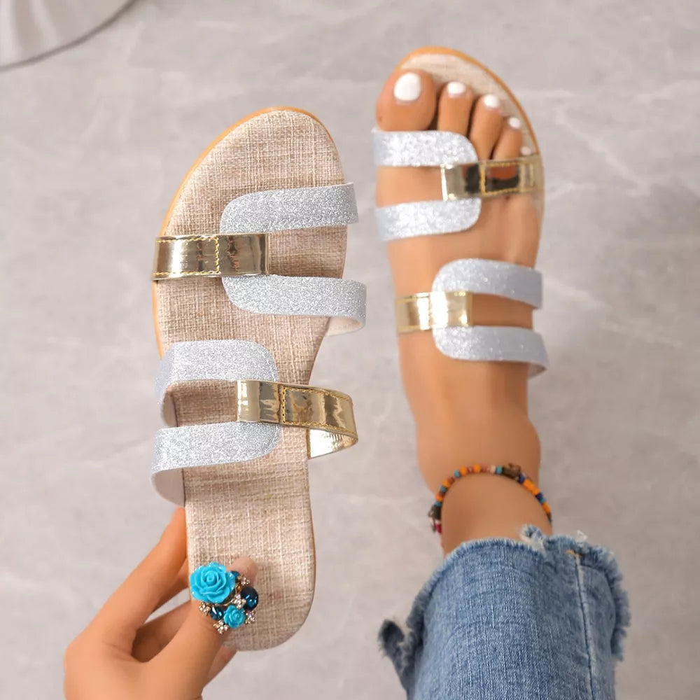 Glistening dual-strap wedge sandals in silver and gold with a textured sole.