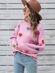 Pink acrylic knit sweater with bubble sleeves and a heart motif.