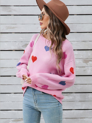 Pink acrylic knit sweater with bubble sleeves and a heart motif.