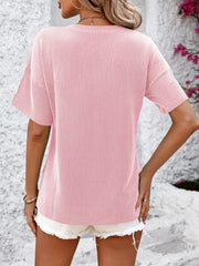 Textured ribbed blush pink V-neck tee with short sleeves and a pocket detail.