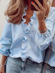Light blue blouse with cascading ruffle front and balloon sleeves.