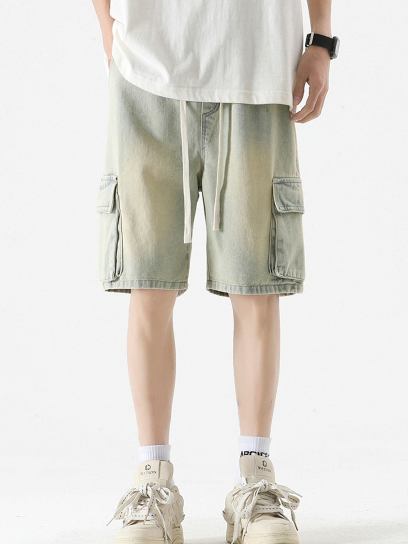 Light wash denim cargo shorts with drawstring and button-flap pockets.