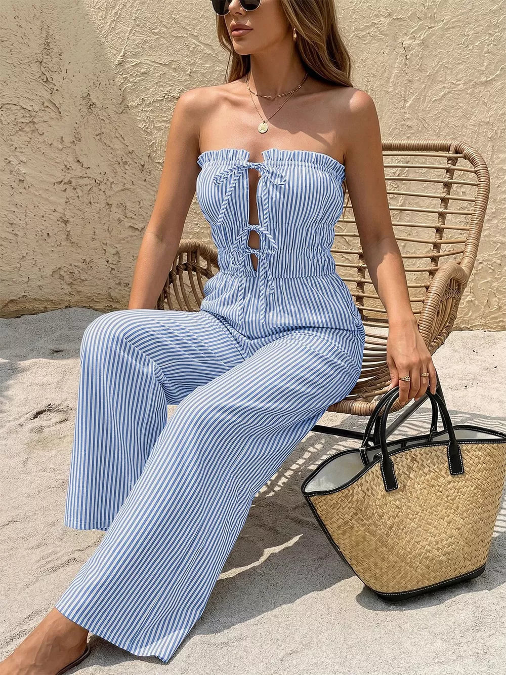 Blue striped strapless romper with smocked waist and tie front detail.