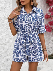 Blue and white printed tie-waist romper with short sleeves and a collared neckline.