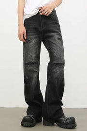 Distressed dark flare jeans with bleach wash and ripped details.
