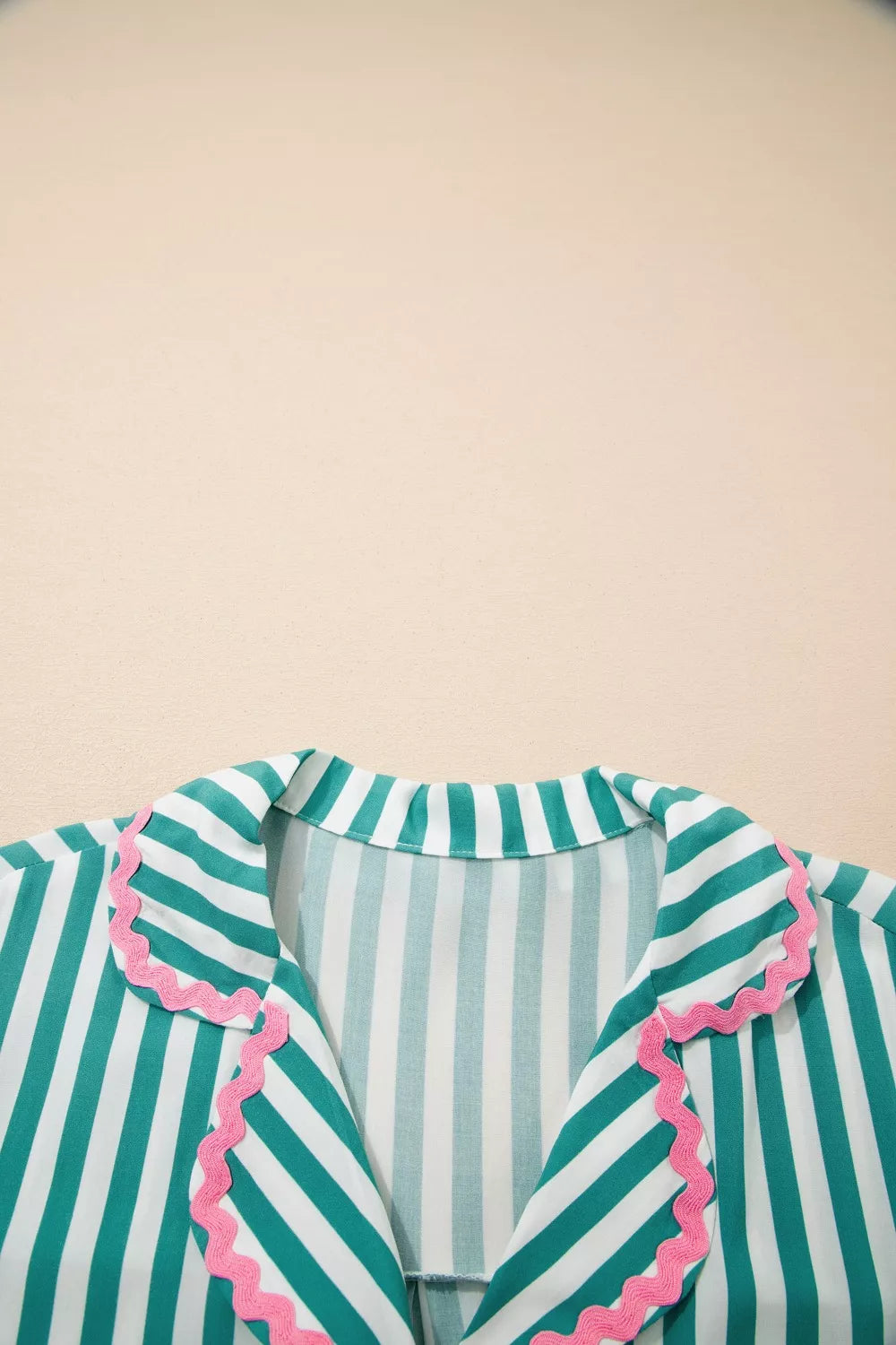 Green and white striped pajama top with pink ruffled collar detail