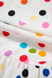 White blouse with rainbow polka dots and ruffled hem detail.