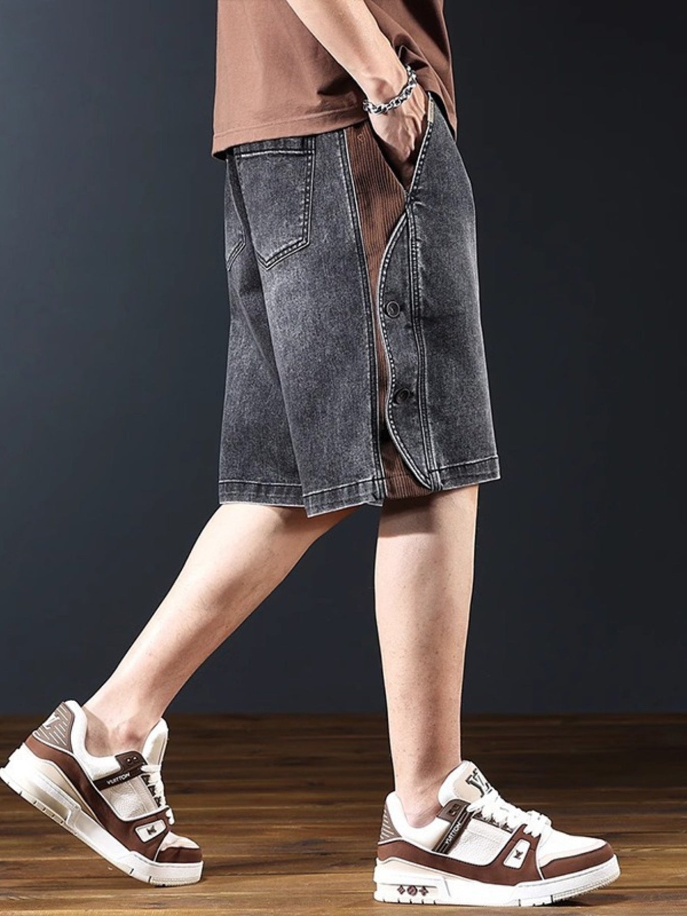 Dark gray wide leg denim shorts with buttoned side detail and brown corduroy panel.