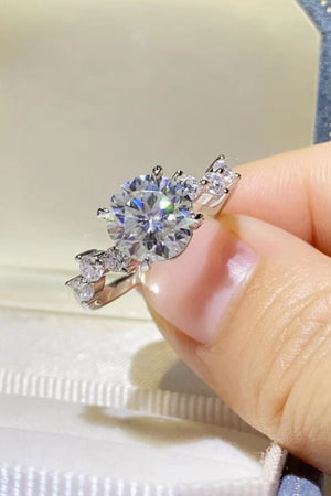 Silver moissanite halo ring with a large center stone and smaller accent stones.