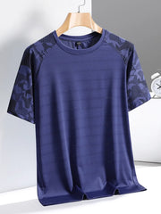 Men's blue activewear tee with patterned raglan sleeves and textured fabric.