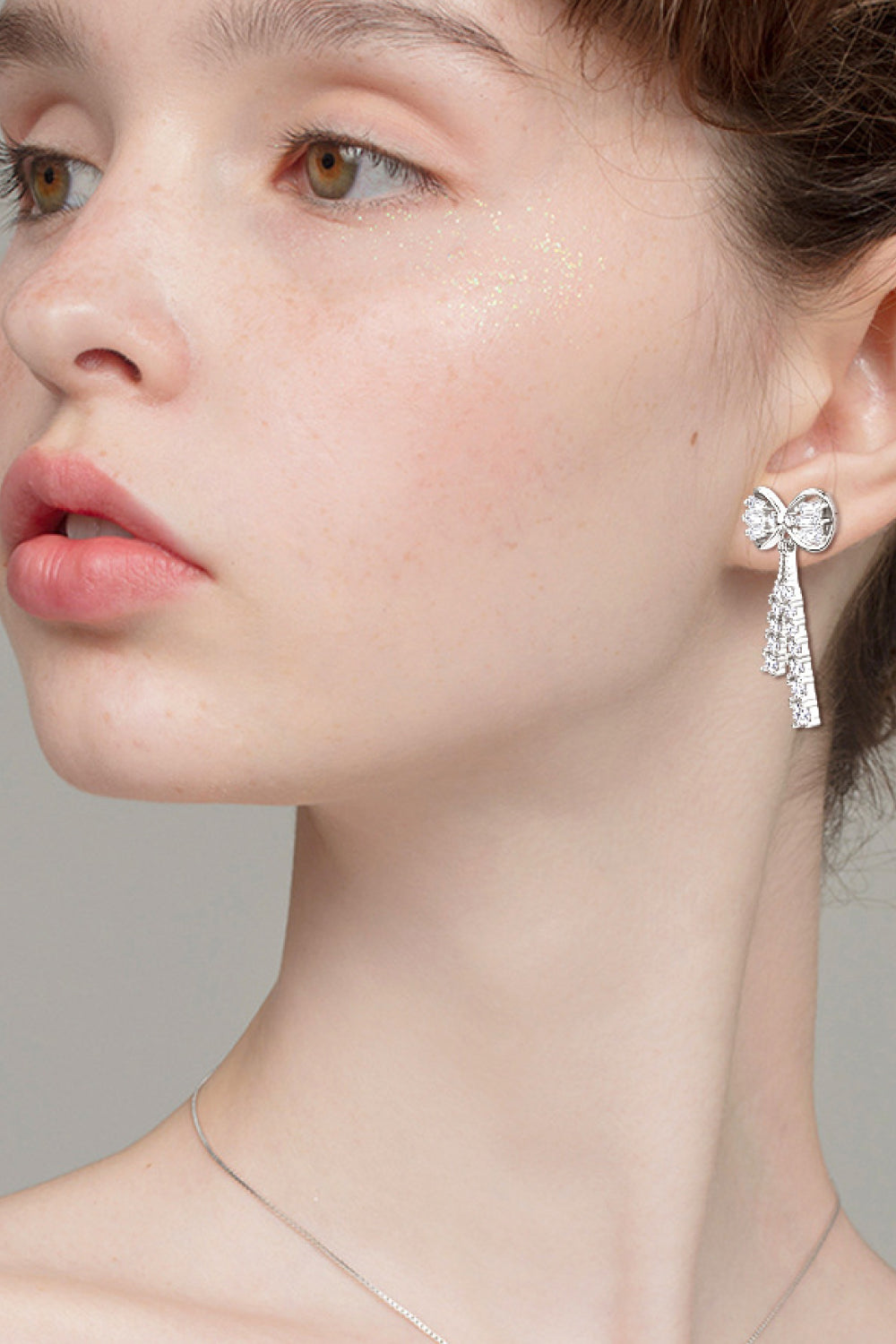 Silver baguette bow drop earrings with sparkling crystal tassels.