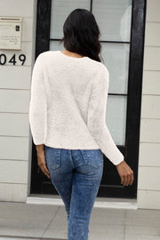 Ivory fluffy knit cardigan with long sleeves, styled with blue jeans.