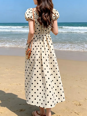 Charming puff sleeve polka dot midi dress with a belted waist and pockets.