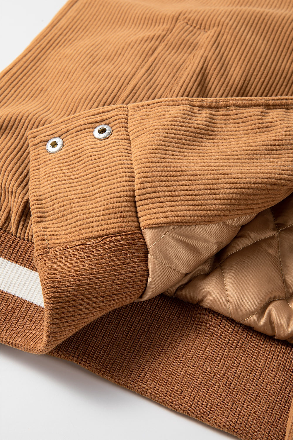 Terracotta corduroy bomber jacket with quilted lining and contrast stripe detail.