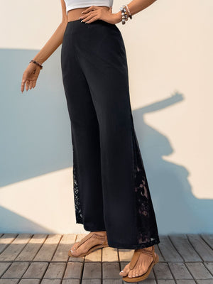 Black palazzo trousers with lace insets on the sides.