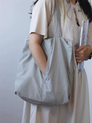 Spacious light blue nylon shoulder bag with exterior slip pocket and comfortable styling.
