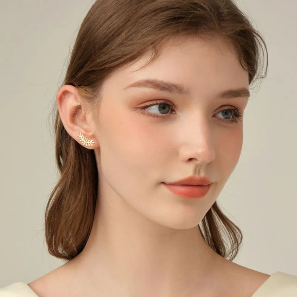 Gold leaf climber earrings with delicate branch design.