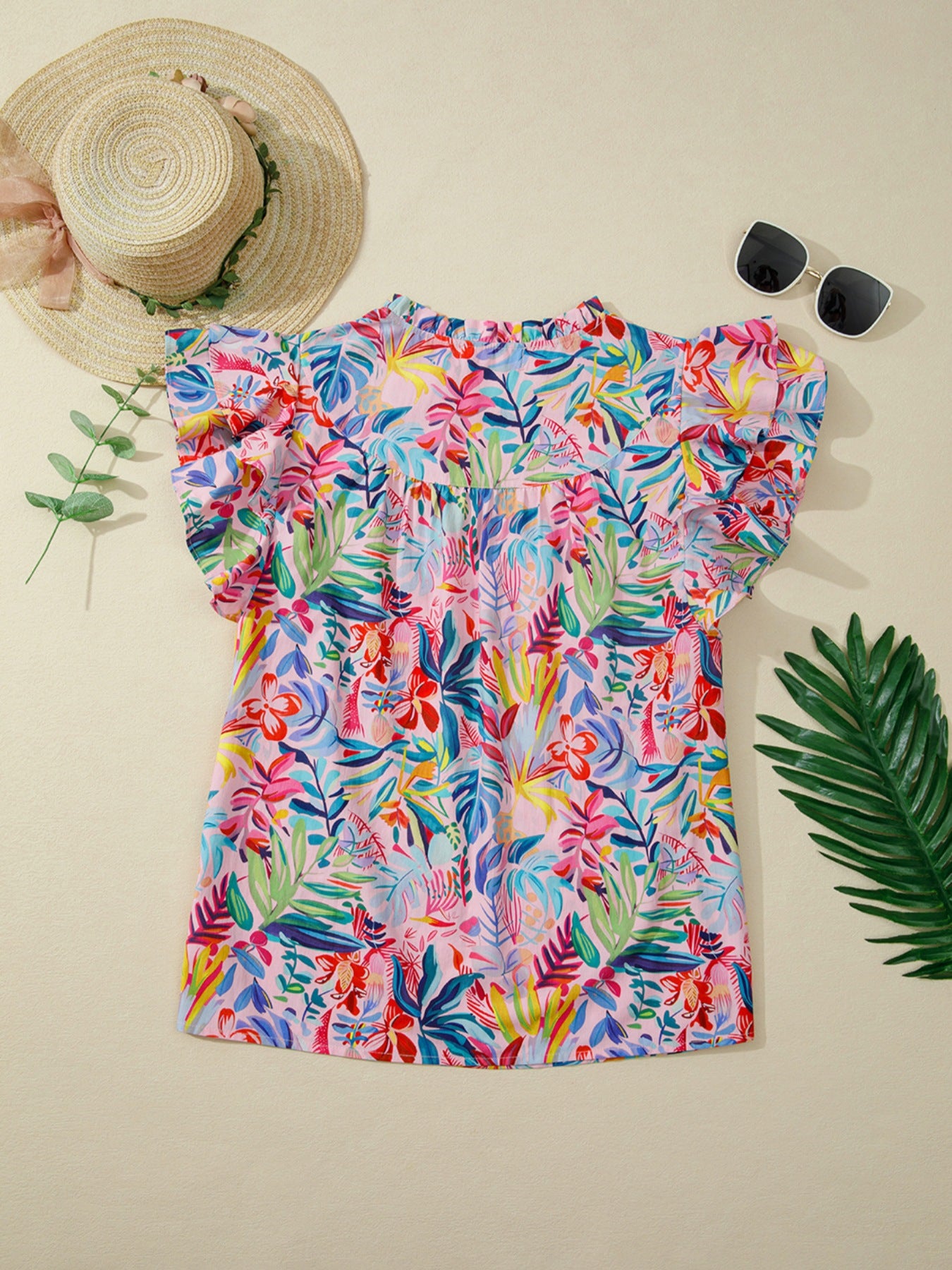 Tropical floral print cotton blouse with ruffled short sleeves and high neckline.