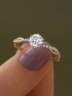 Gold twisted pavé zircon engagement ring with a central round-cut stone.