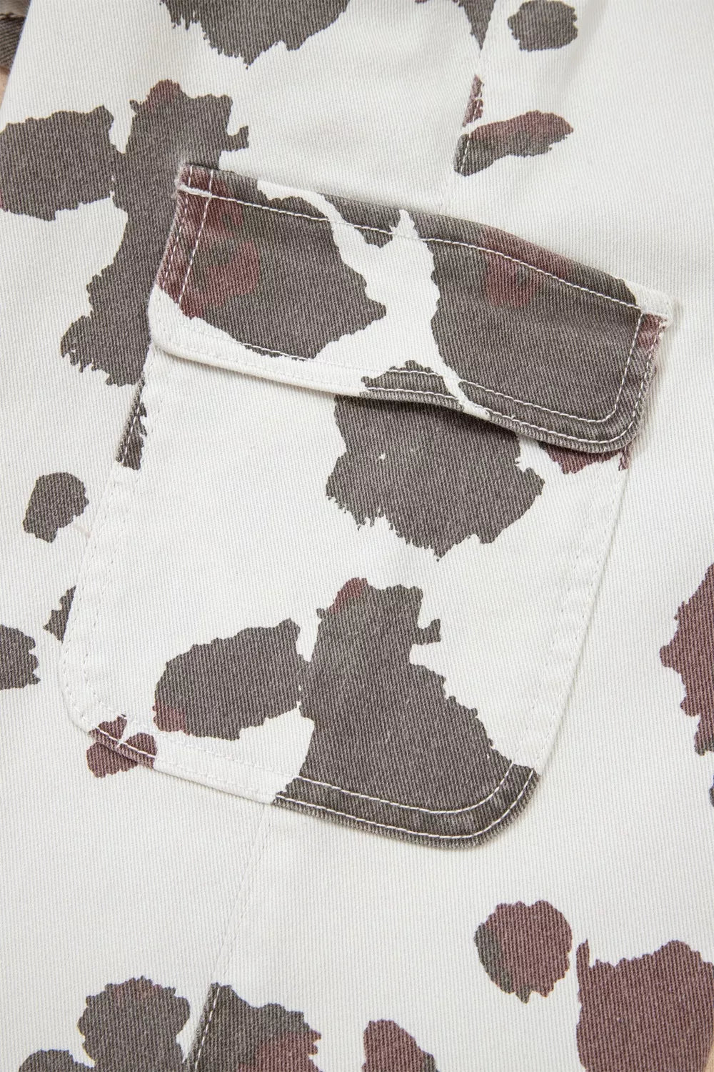 Cow print utility jeans with cargo pocket detail.
