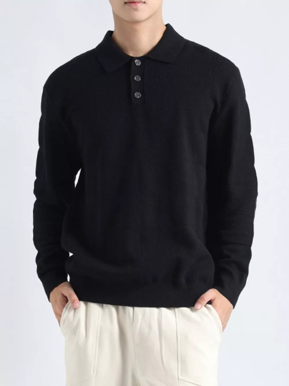 Black knit polo top with button accents and long sleeves.