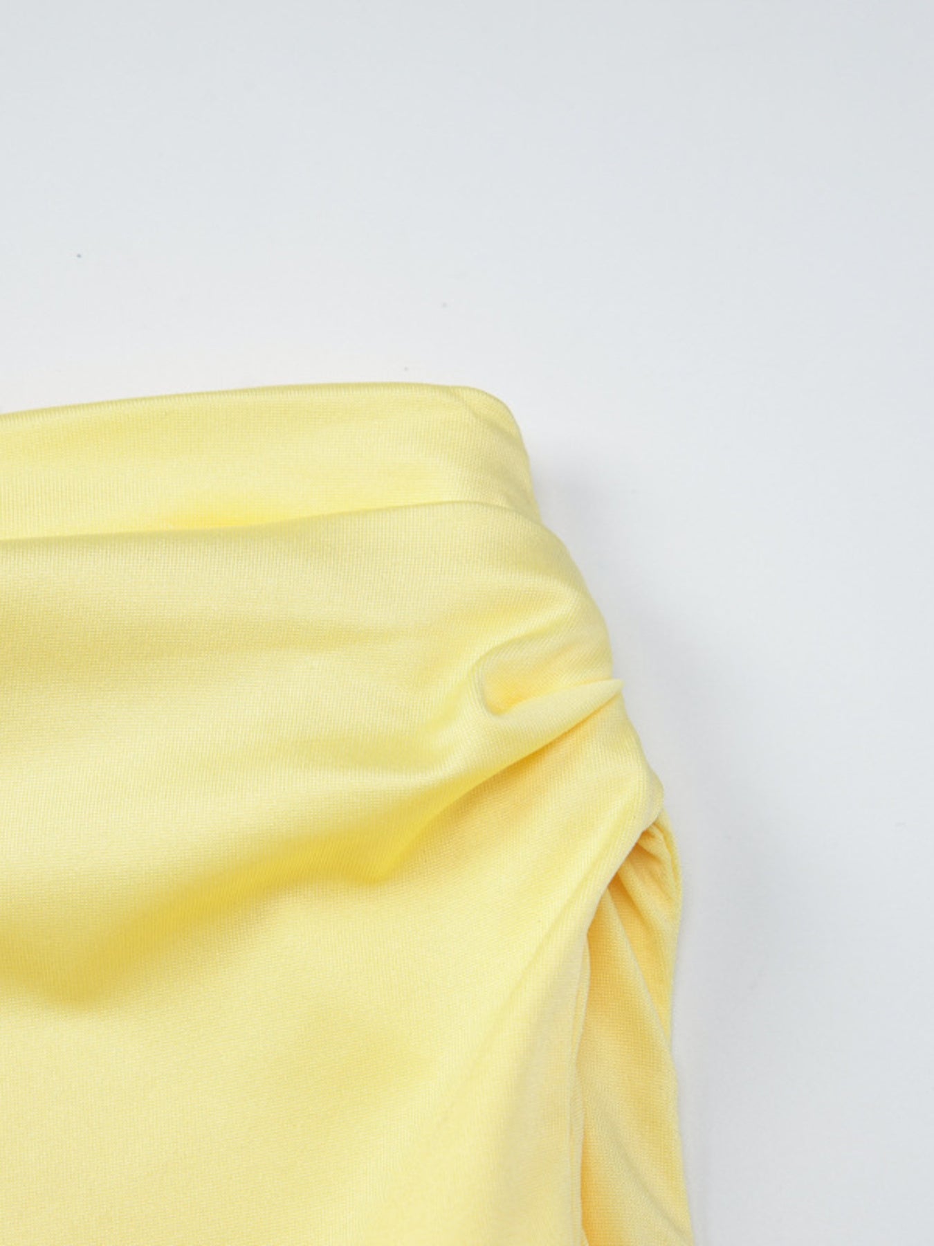 Yellow off-shoulder ruched mini dress detail showing gathered fabric and neckline.