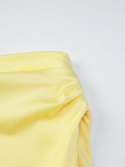 Yellow off-shoulder ruched mini dress detail showing gathered fabric and neckline.