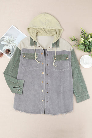 Colorblock corduroy utility jacket with hood, featuring gray, sage green, and tan panels, and chest pockets.