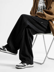 Black casual loose fit sweatpants with a wide leg, styled with sneakers.