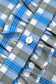 Blue plaid button-down blouse with frilled detail and white button.