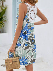 Botanical print mini dress with white crochet back detail and blue flowers.