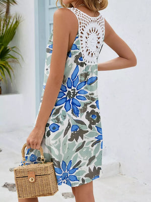 Botanical print mini dress with white crochet back detail and blue flowers.