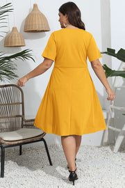 Mustard yellow midi dress with short sleeves and a flared skirt.