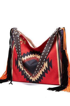 Southwestern hobo bag in red with geometric pattern, fringe detail, and leather strap.
