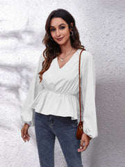 White peplum blouse with V-neck, gathered waist, and balloon sleeves.
