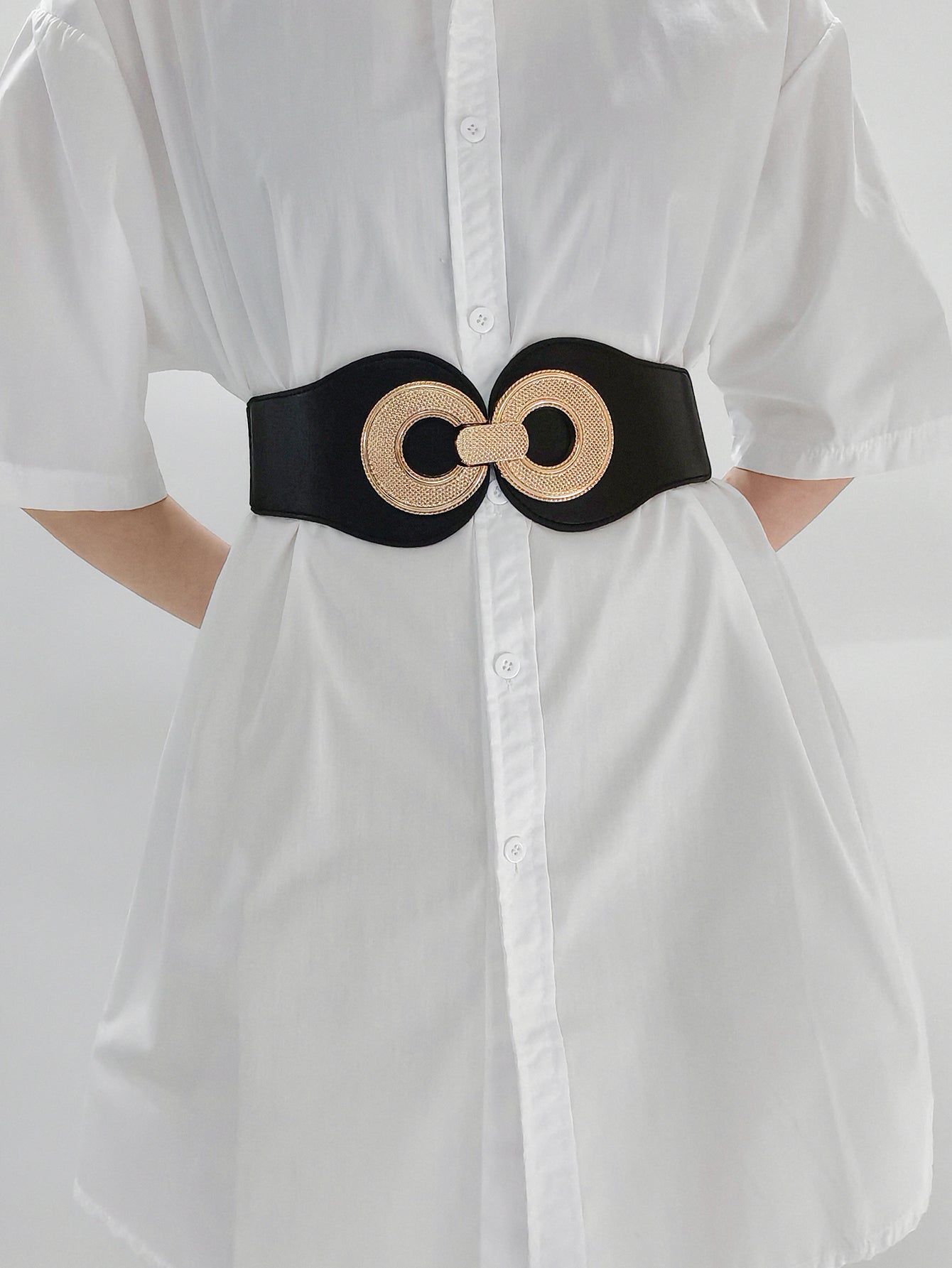 Black elastic belt with gold metalwork double circle clasp cinches waist