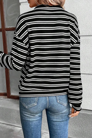 Black and white striped ribbed half-zip pullover sweater with long sleeves.