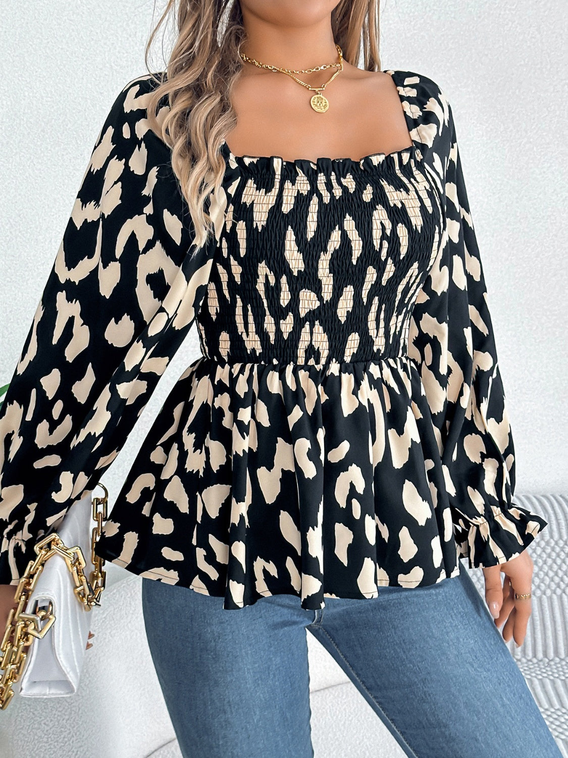 Black and cream leopard print smocked bodice square neck blouse with ruffled cuffs.