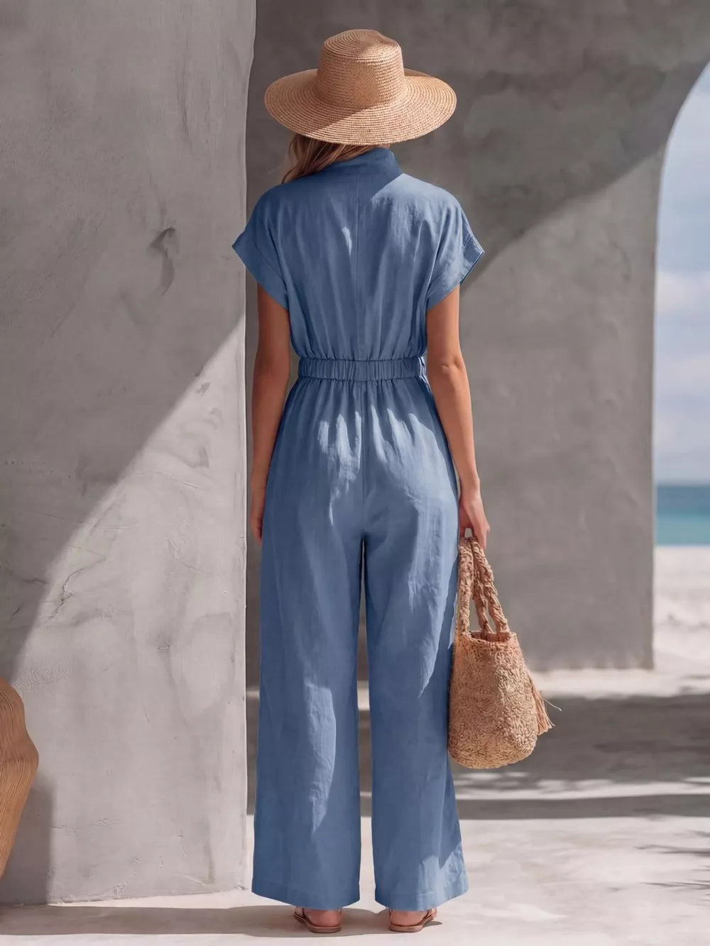 Blue wide-leg maternity jumpsuit with short sleeves and elastic waist, shown from the back.