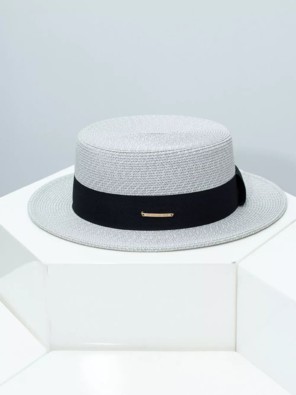 Gray straw boater hat with black ribbon and gold accent detail