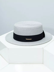 Gray straw boater hat with black ribbon and gold accent detail