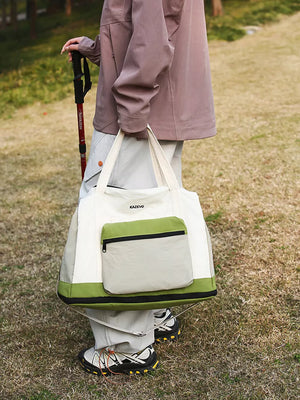 Chic nylon travel bag in green and white with front zip pocket and dual straps.
