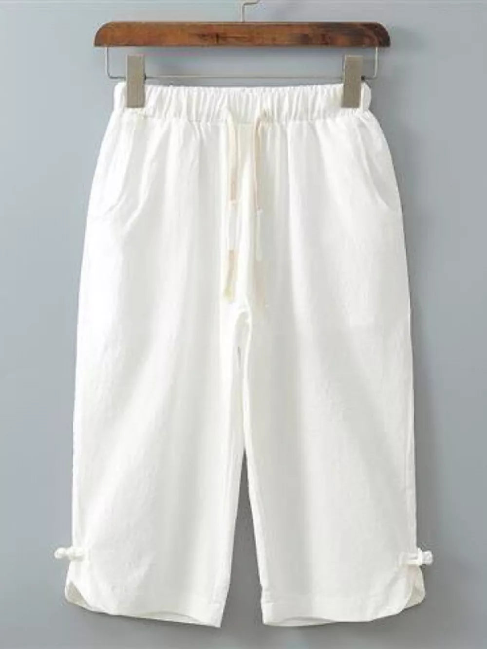 White cropped sweatpants with drawstring waist and tie detail at hem
